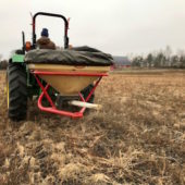 Broadcasting prairie seed with a Vicon® seeder.